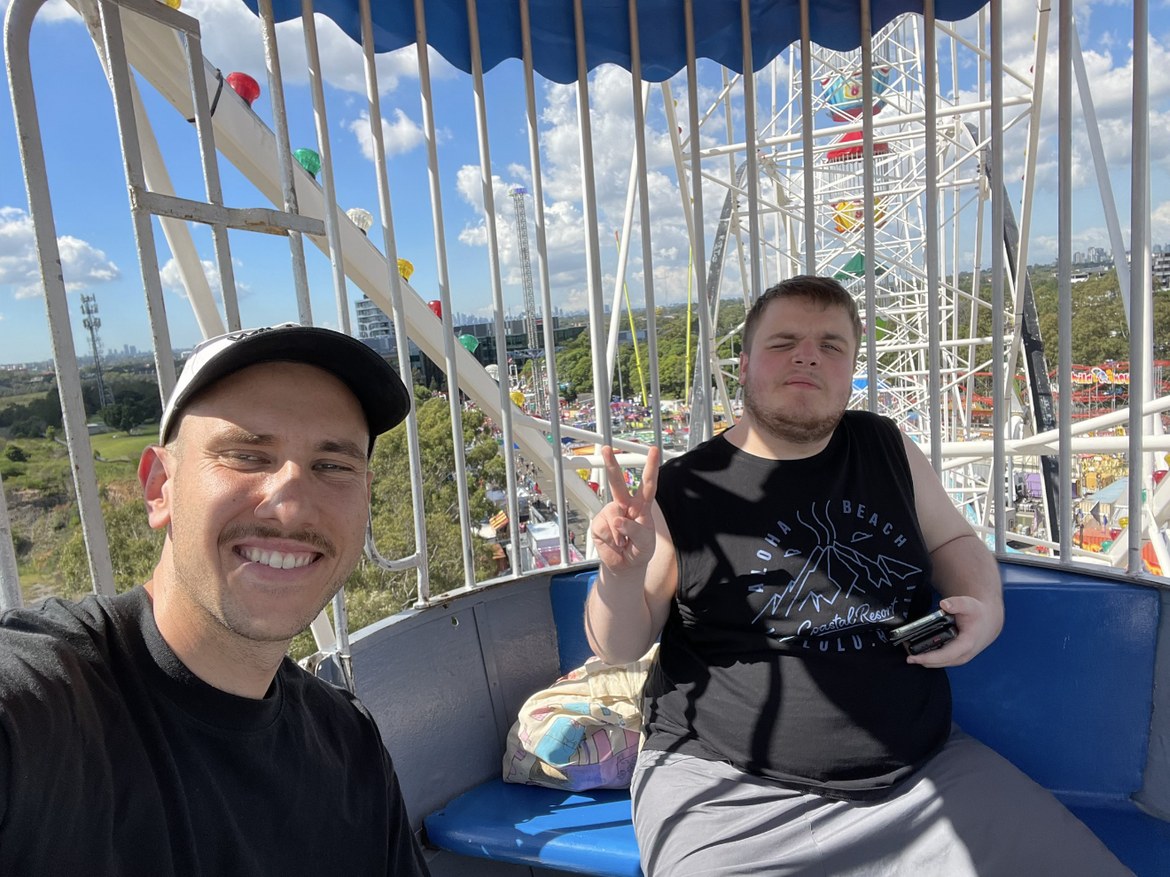 Support worker and participant riding a ferris wheel together